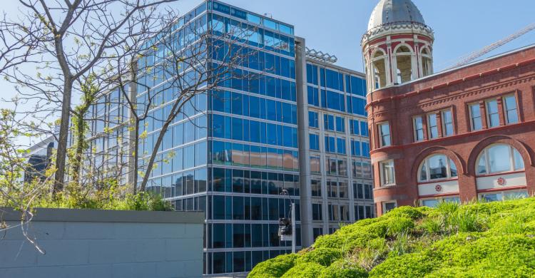 A modern office building next to a historic brick building.